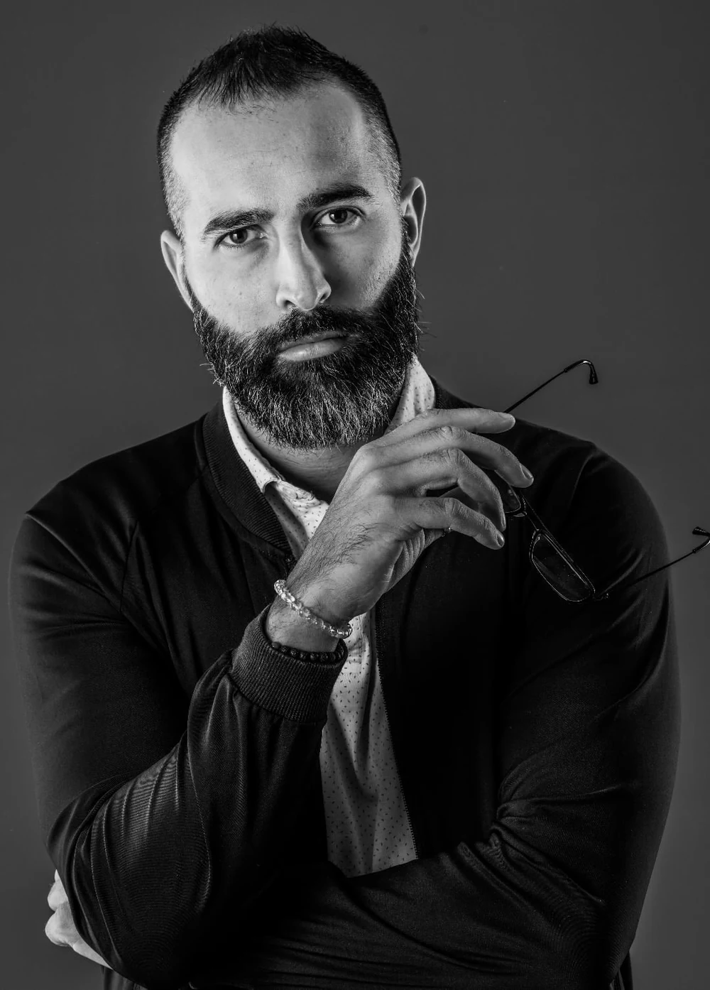 Sébastien Jimenez, portrait en noir et blanc, lunettes à la main